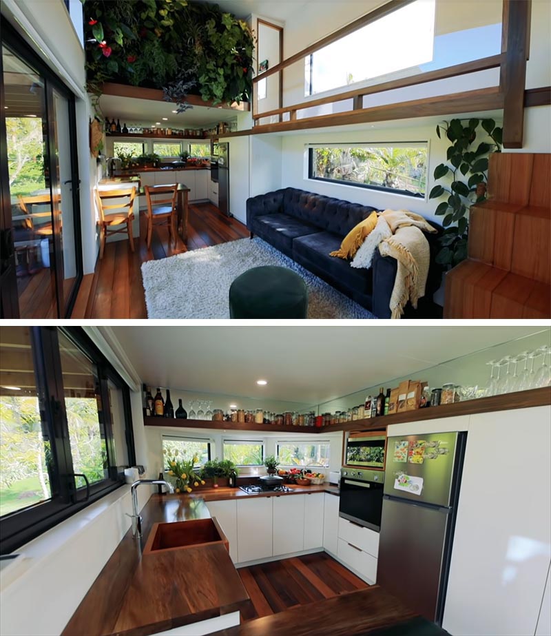 A modern tiny house with an open plan living room and kitchen, and an interior green wall.